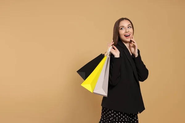 Stylische Junge Frau Mit Einkaufstaschen Auf Beigem Hintergrund Platz Für — Stockfoto