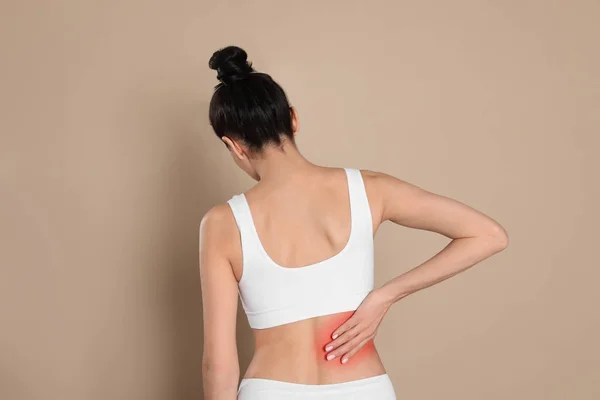 Mujer Que Sufre Dolor Espalda Sobre Fondo Beige —  Fotos de Stock
