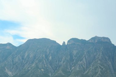 Bulutlu bir günde yeşilliklerle kaplı görkemli dağ manzarası