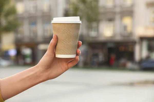 女人拿着纸杯在城市街道上 特写与文字的空间 咖啡好了 — 图库照片