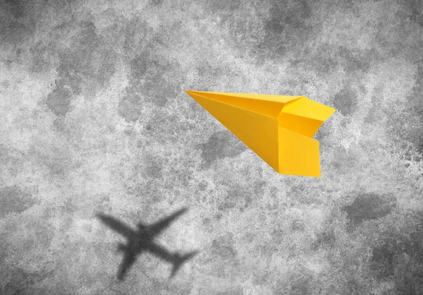 Fliegendes Papierflugzeug Und Schatten Eines Echten Flugzeugs Auf Asphalt — Stockfoto