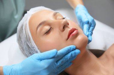 Young woman receiving facial massage in salon