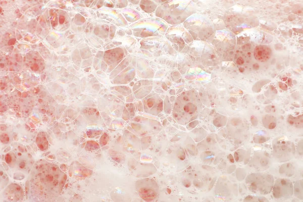 淡いピンクの背景に白い泡を洗う トップビュー — ストック写真