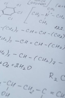 Farklı matematiksel formüllere sahip bir sayfa kağıt, yakın plan.