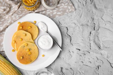 Gri masada servis edilen tatlı çekirdekli ve soslu leziz mısır krepleri. Metin için boşluk