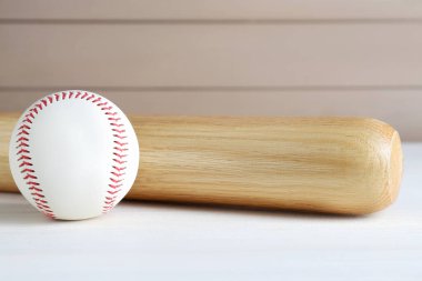 Beyzbol sopası ve top beyaz tahta masada. Spor malzemeleri.