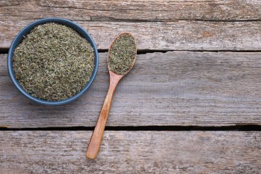Tahta masada kuru kekik ve kaşık tabağı, düz. Metin için boşluk