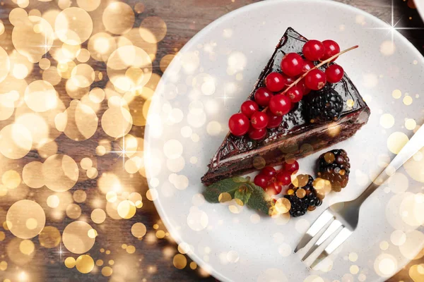 Yummy chocolate cake with berries on wooden table, top view. Tasty dessert for Christmas dinner