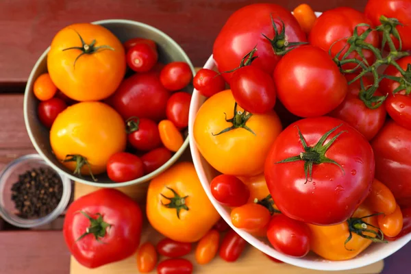 Taze domates ve baharatlarla dolu kaseler ahşap masada, düz yatıyordu.