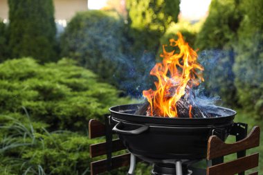 Dışarıda alevler içinde taşınabilir barbekü ızgarası. Metin için boşluk