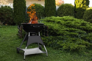 Dışarıda alevler içinde taşınabilir barbekü ızgarası. Metin için boşluk