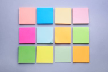 Açık mor arkaplan üzerine kağıt notlar, düz yatış