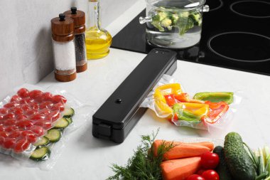 Elektrikli süpürge ambalajı için mühür. Mutfakta tezgahta plastik dolma biber torbası var.