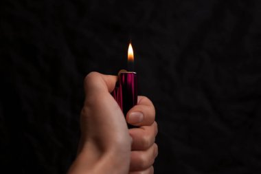 Siyah arka planda çakmak tutan kadın, yakın plan.