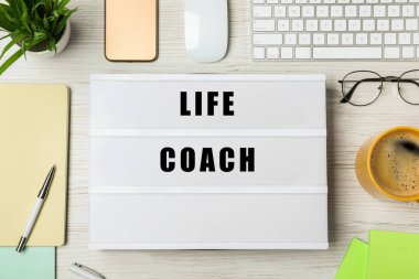 Yaşam koçu ve kırtasiye malzemesi ahşap masada, düz yatıyordu.