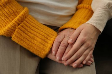 Genç ve yaşlı kadınlar el ele tutuşup, yakınlaşırlar.