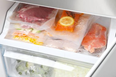 Buzdolabında farklı ürünler olan vakum torbaları. Yiyecek deposu