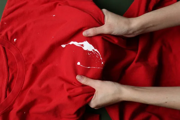 Mulher Segurando Camisa Vermelha Com Mancha Tinta Branca Fundo Verde — Fotografia de Stock