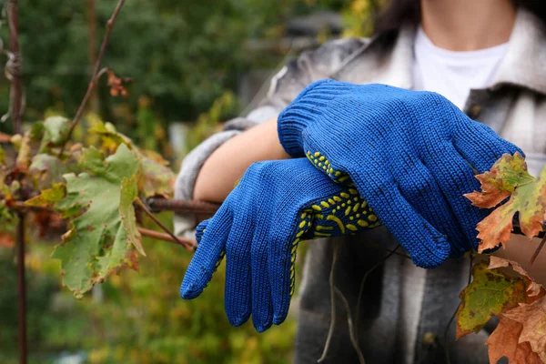 Woman wearing gloves having rest in garden, closeup