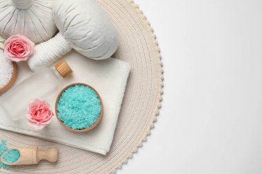 Güzel bir spa kompozisyonu, bitkisel masaj torbaları ve beyaz arka planda farklı bakım ürünleri, üst manzara. Metin için boşluk