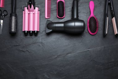 Profesyonel kuaför araçlarının düz kompozisyonu koyu gri masa üzerinde, metin için boşluk