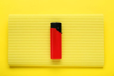 Sarı arka planda kıvrımlı lifli küçük cep çakmağı, üst görünüm