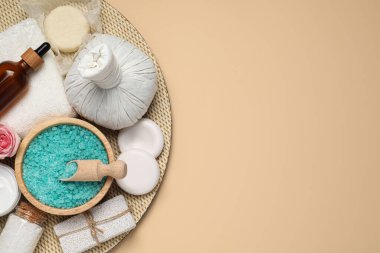 Bej arka planda bitkisel poşet ve spa ürünlerinin kompozisyonu, üst manzara. Metin için boşluk