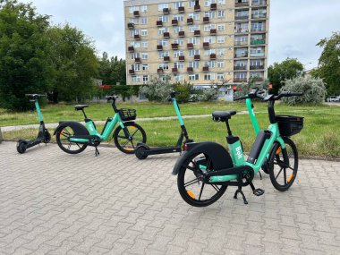 Şehrin caddesinde park edilmiş elektronik scooter ve bisikletler.