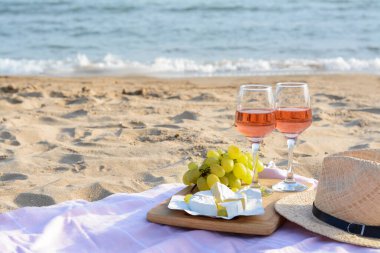 Gül şarabı ve kumlu sahilde atıştırmalık bardaklar. Metin için boşluk