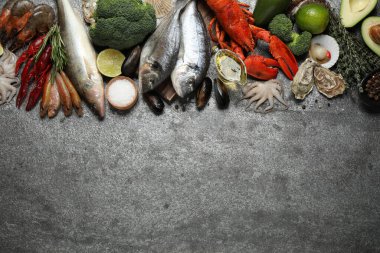 Taze balık ve farklı deniz ürünleri gri masada, düz yerde. Metin için boşluk