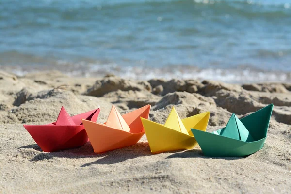 Many paper boats near sea on sunny day