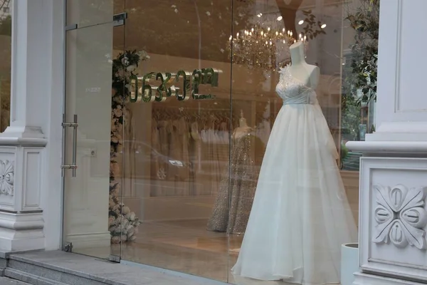 Showcase with beautiful wedding dress on mannequin