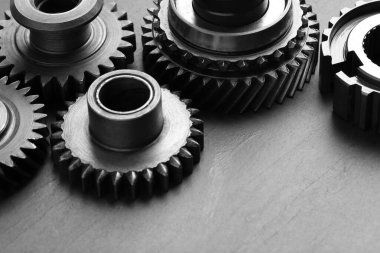 Gri arka planda farklı paslanmaz çelik dişliler, yakın plan