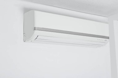 Beyaz duvarda asılı modern klima.