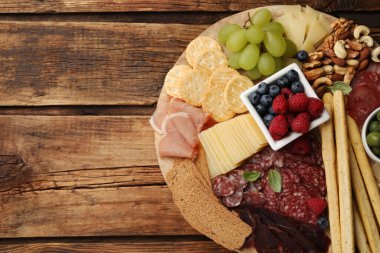 Ahşap masanın üstünde nefis parmesan peynirli abur cubur seti, üst manzara. Metin için boşluk