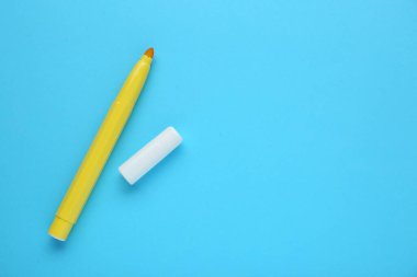 Açık mavi arka planda parlak sarı işaret ve kep, düz yerde yatıyordu. Metin için boşluk