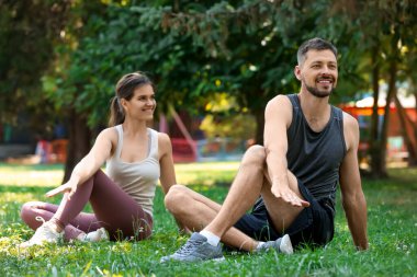 Erkek ve kadın parkta sabah egzersizi yapıyor.