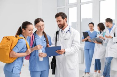 Tıp öğrencilerinden oluşan bir ekip üniversite koridorunda, mesaj için yer var.