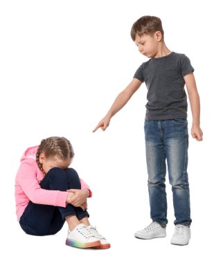 Beyaz arka planda üzgün bir kızı işaret eden bir çocuk. Çocukların zorbalığı.