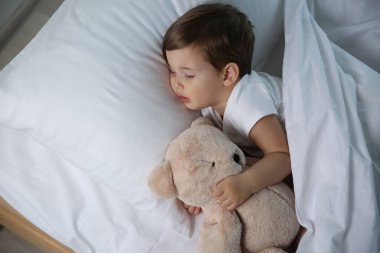 Evde oyuncakla uyuyan şirin bir bebek. Yatma zamanı.