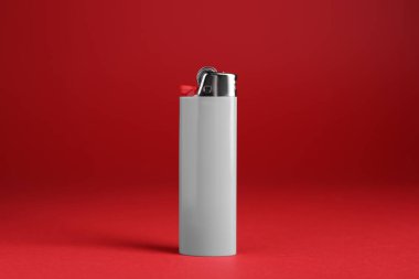 Kırmızı arkaplanda küçük cep çakmağı kullan