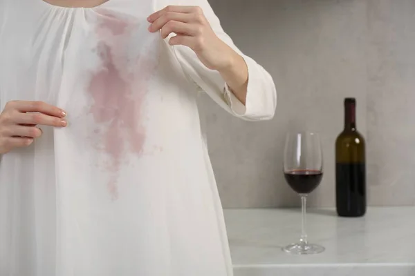 Woman with wine stain on her clothes indoors, closeup. Space for text