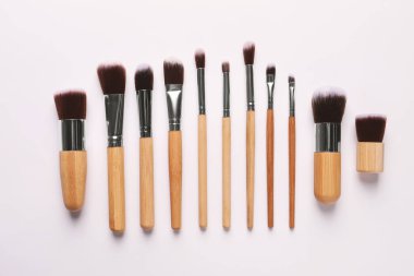 Beyaz arka planda farklı makyaj fırçaları, düz yatış