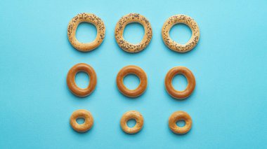 Açık mavi zemin üzerinde birçok farklı lezzetli halka şekilli Sushki (kuru simit), düz yatıyordu