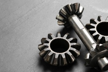 Açık gri arka planda farklı paslanmaz çelik dişliler, yakın plan. Metin için boşluk