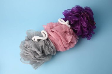 Açık mavi arka planda renkli duşlu puflar, düz uzanmış