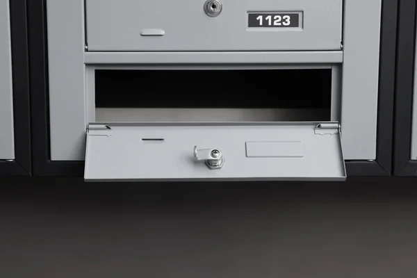 Open empty metal mailbox with keyhole indoors