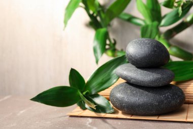 Paspasın üzerine yığılmış spa taşları ve bambu. Metin için boşluk