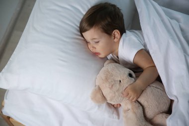 Evde oyuncakla uyuyan şirin bir bebek. Yatma zamanı.