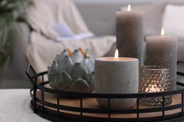 Kapalı alanda yanan mumlarla dolu tepsi.